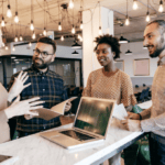 Retail-specific fraud experts conferring around a laptop in a modern office.