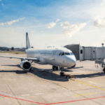 An airplane on the tarmac with jetway, to illustrate Signifyd loyalty fraud blog post