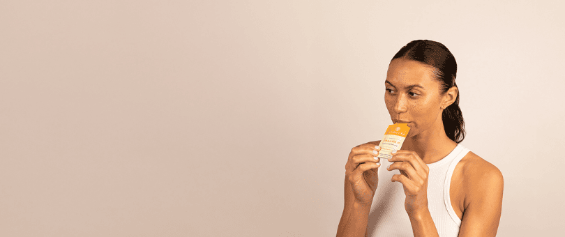 A woman consuming Cymbiotika vitamin supplement